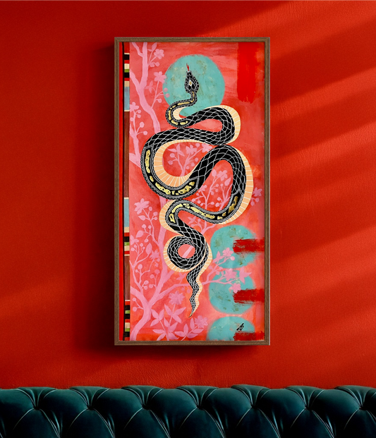 Framed artwork with a snake design on a red wall above a green sofa.
